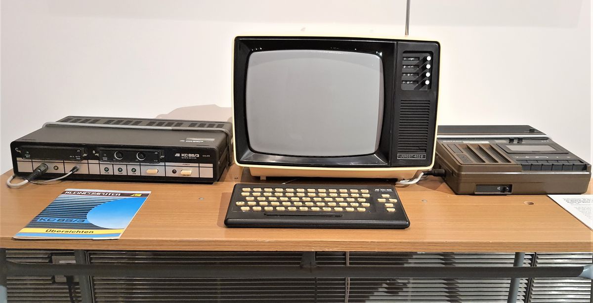 zur Vergrößerungsansicht des Bildes: Zu sehen sind ein Computer der Marke Robotron, ein Monitor und ein Kassettenlaufwerk