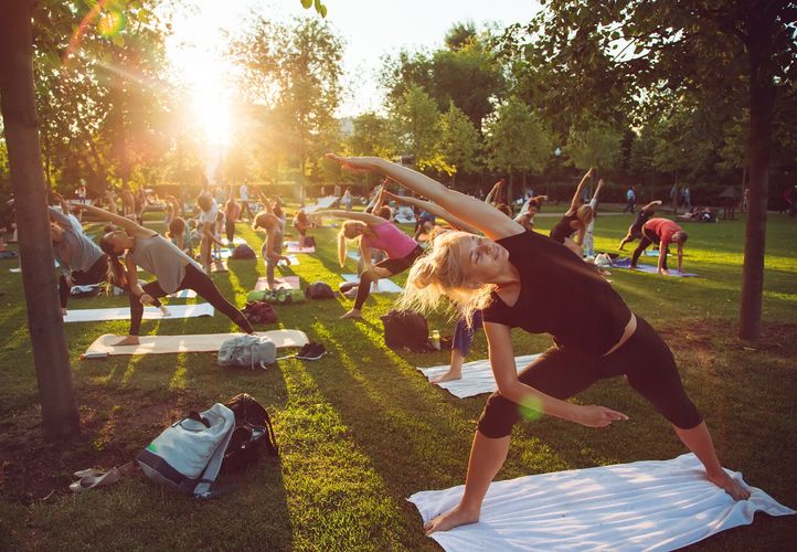 Zu sehen sind Stretching-Übungen im Park.
